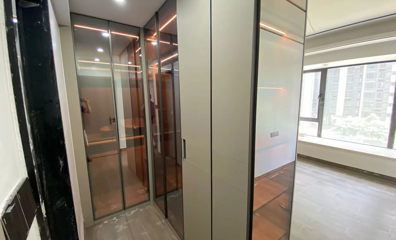 L-shaped wardrobe with tea-tinted glass and an open dressing area L-shaped wardrobe with tea-tinted glass and an open dressing area