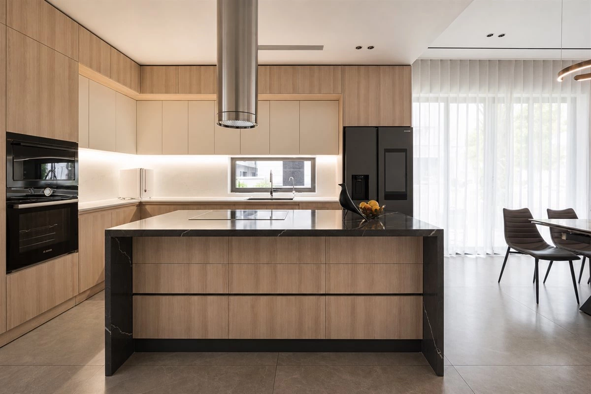 Oak wood cabinets with sintered stone countertop in an L-shaped kitchen