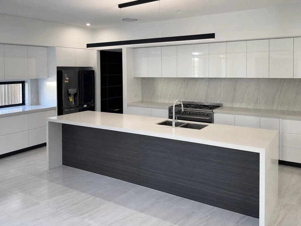 Wide view of white kitchen units and a textured island in a Spain villa