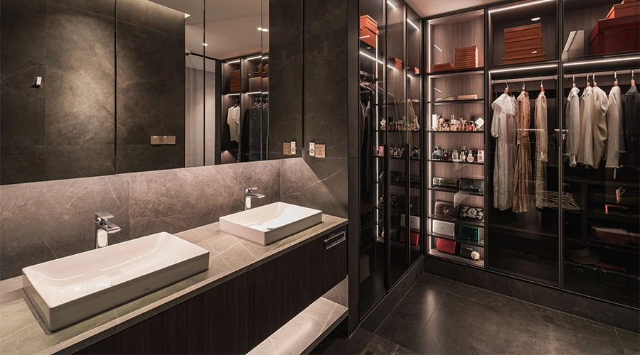 Double vanity in a bathroom closet suite with floating walnut cabinet