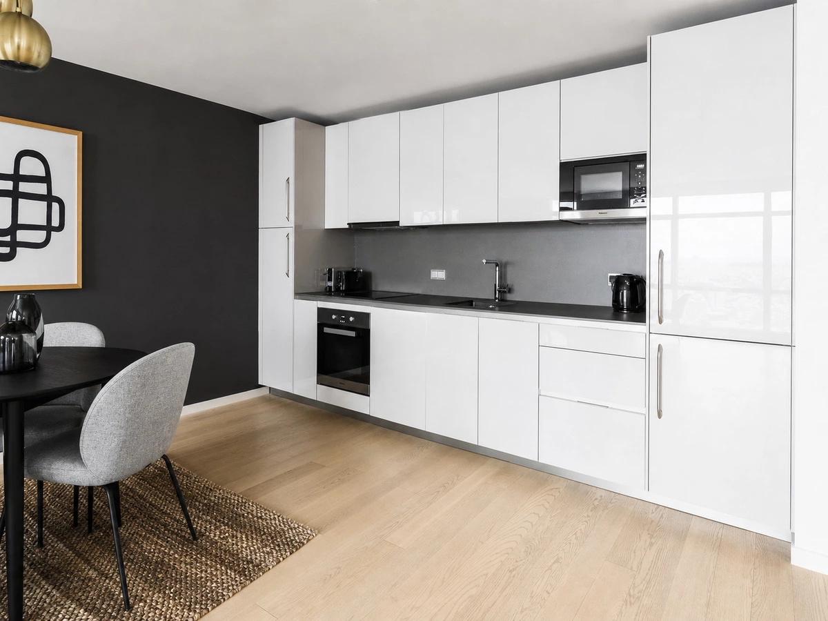 Gloss white kitchen cabinets with a grey backsplash and black details