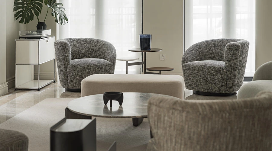 Symmetrical living room with a curved sofa, pendant light, and soft neutral furnishings