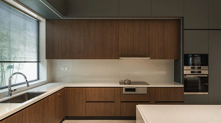Quartz worktop and handleless cabinetry in an illuminated stone kitchen