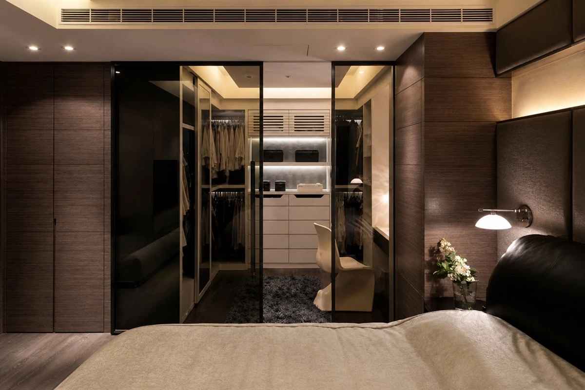 Bedroom walk-in closet next to bathroom with built-in wardrobe storage