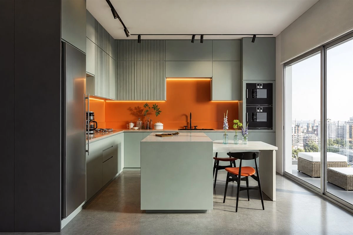 Burnt orange and mint green kitchen cabinets with contrasting island