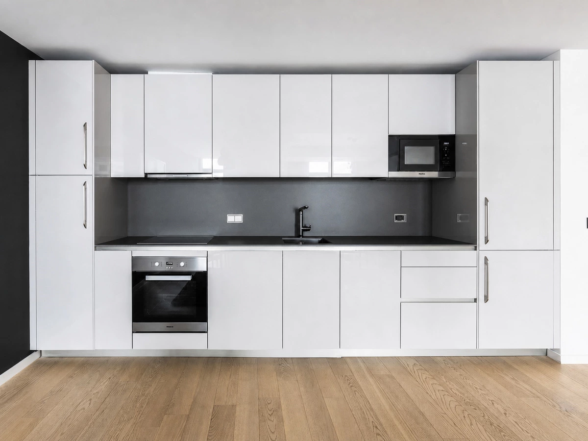 I-shaped kitchen workflow and drawer storage in a black and white apartment kitchen