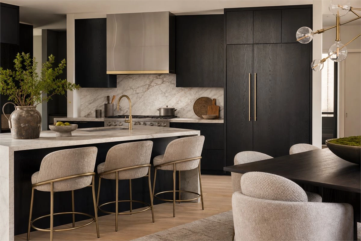 Black painted wood kitchen cabinets paired with marble and metal details