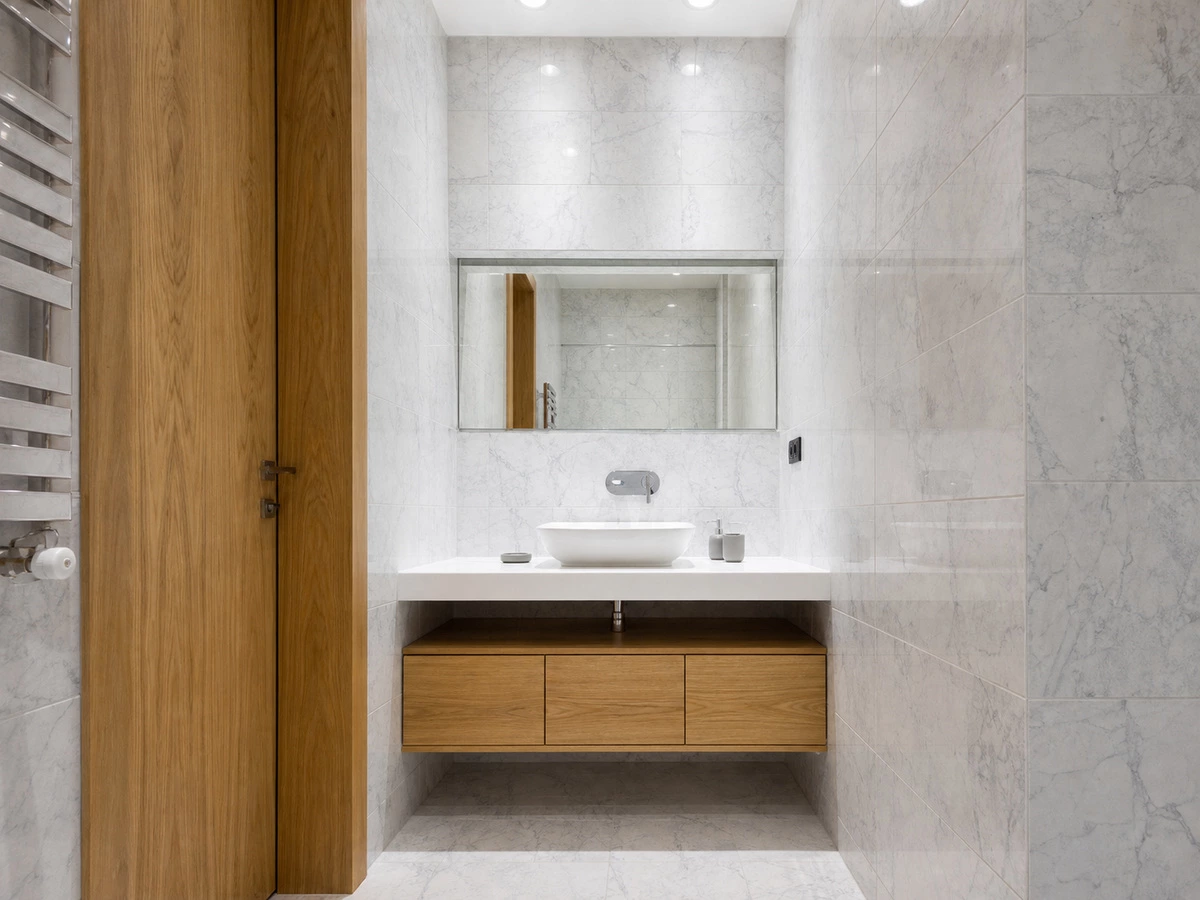 Wood-finish bathroom vanity balancing a white apartment interior