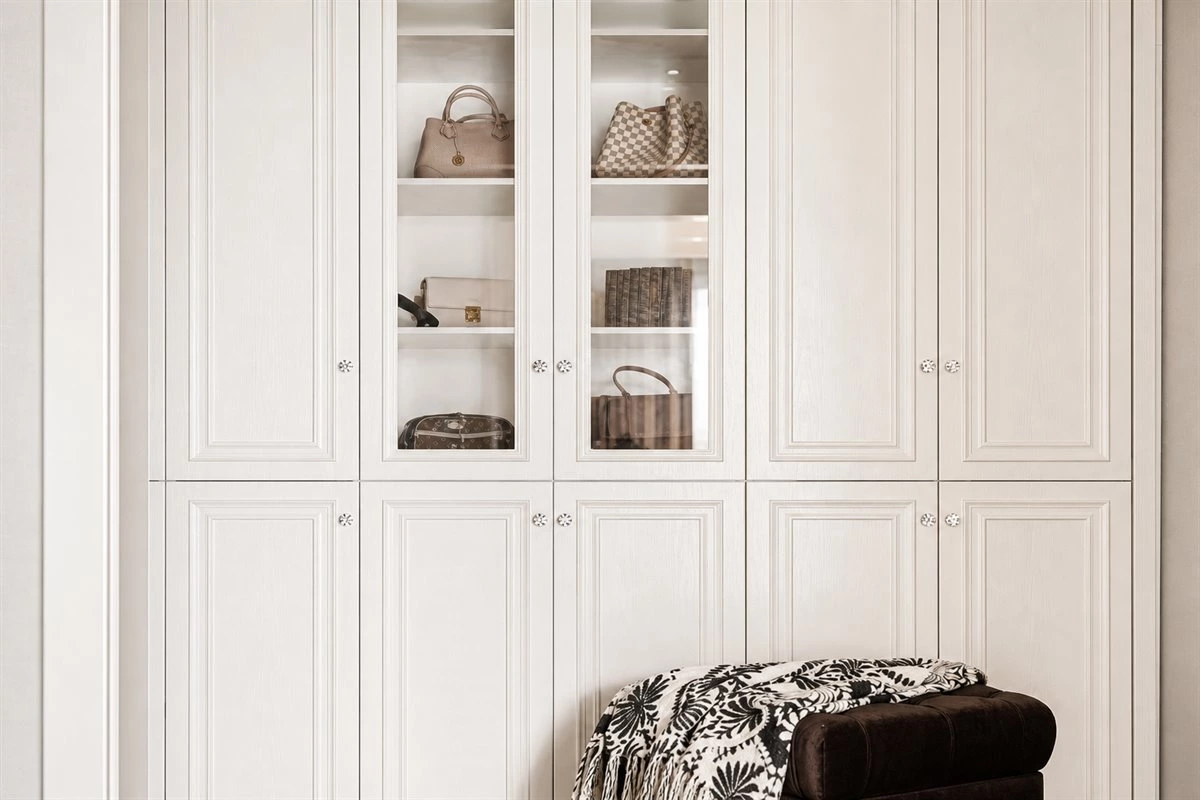 Linear dressing room with elegant wardrobe storage Linear dressing room with elegant wardrobe storage and brown velvet stool