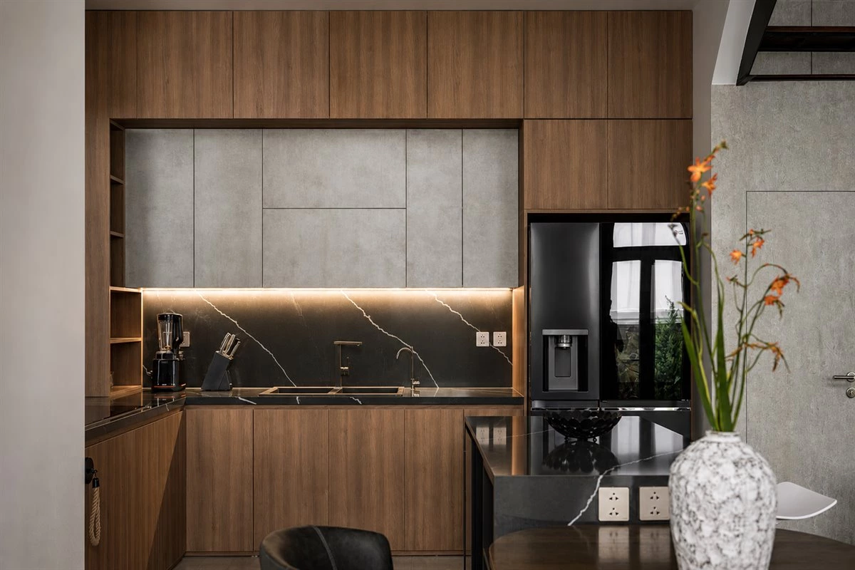 Dark wood and black sintered stone L-shaped kitchen with dining island