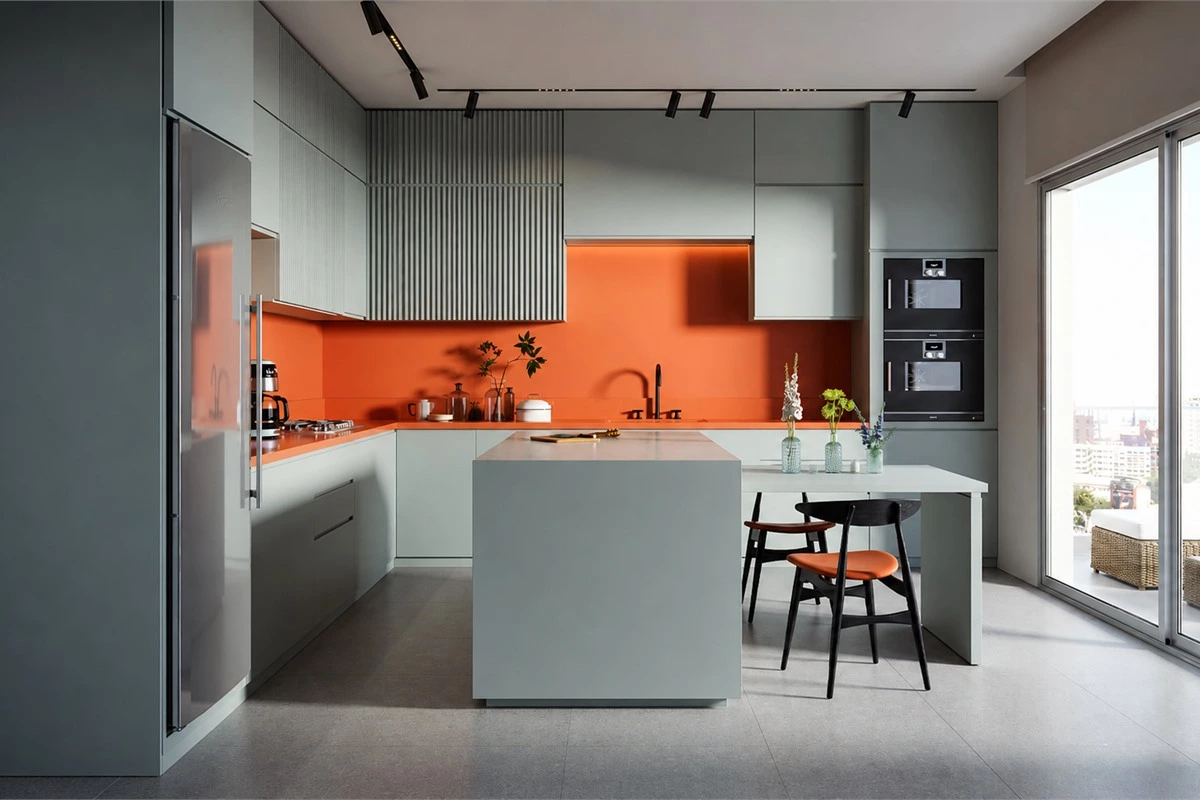 Mint green kitchen cabinets with burnt orange island and fluted cabinet surface