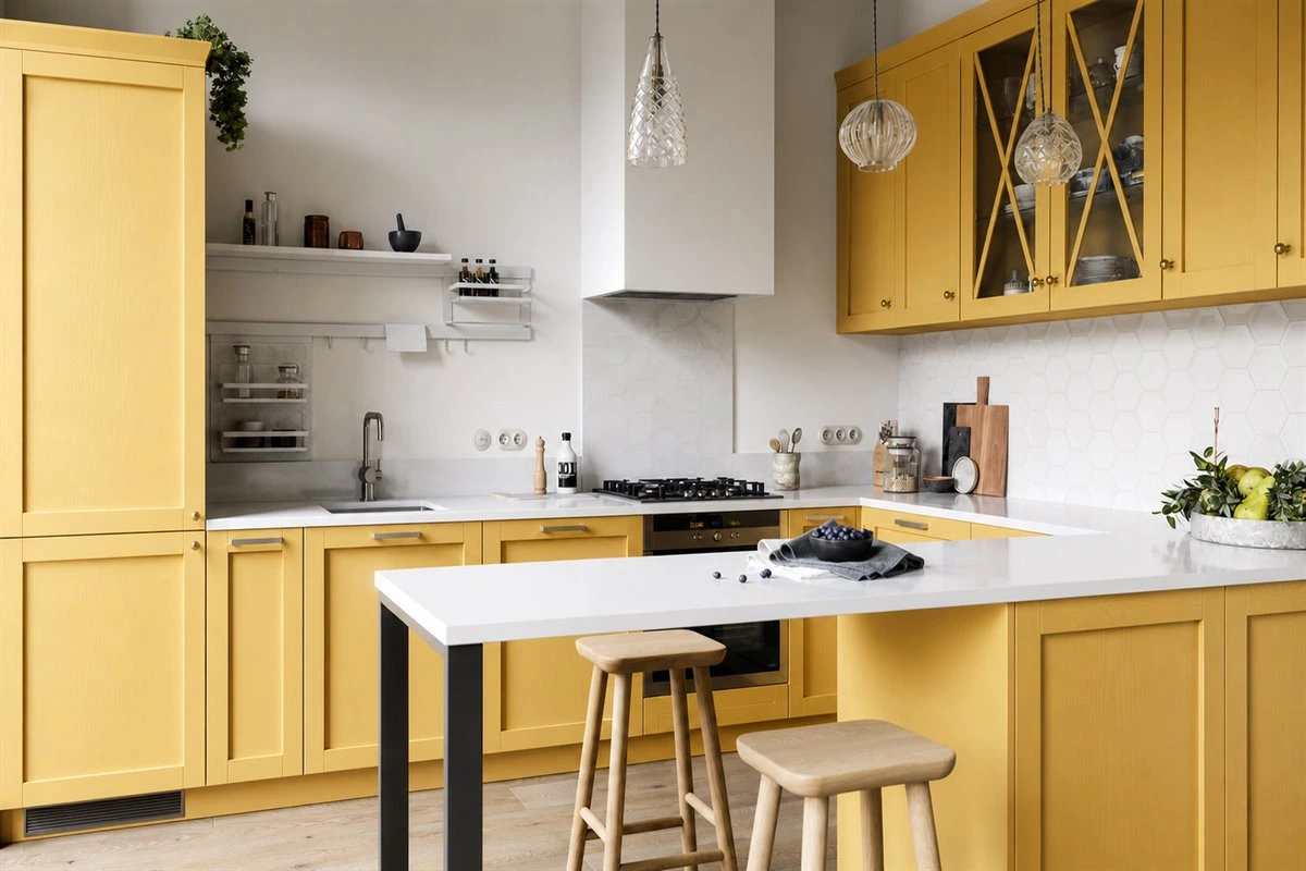 Yellow U-shaped kitchen cabinets with white countertop and wood floor
