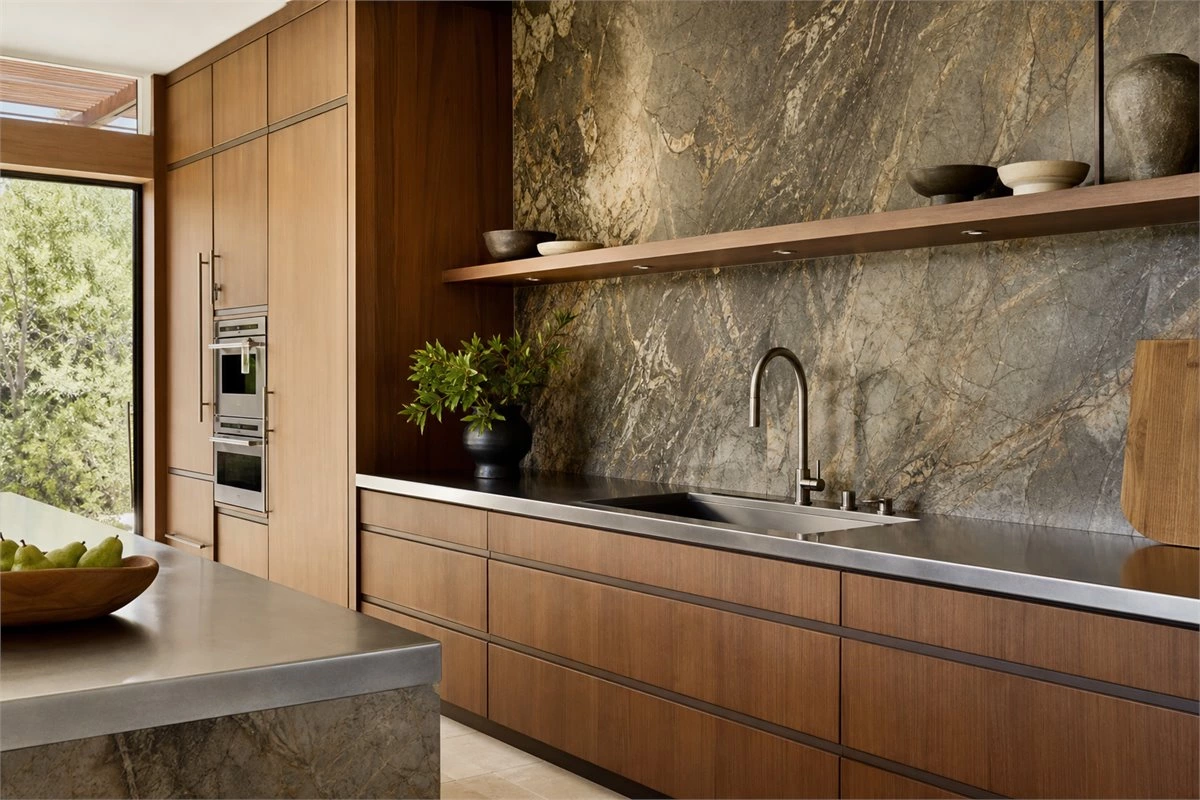 Stainless steel countertop with stone backsplash and natural wood kitchen cabinets