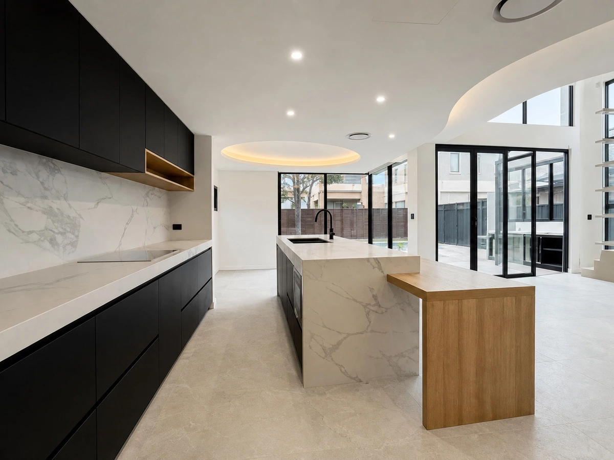 Minimalist black kitchen with handleless cabinetry in a Sydney duplex villa