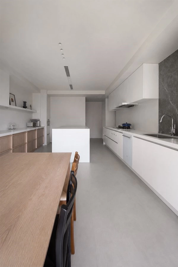 White Kitchen with a Dining Island and Wood Accents