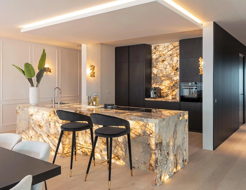 Backlit stone kitchen with a matte black cabinet wall and illuminated island