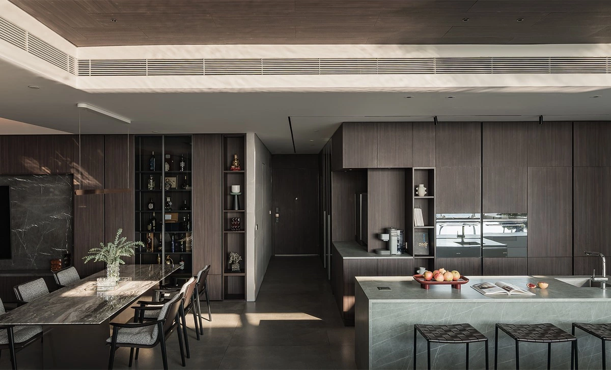 Dark walnut media wall coordinated with walnut kitchen cabinets